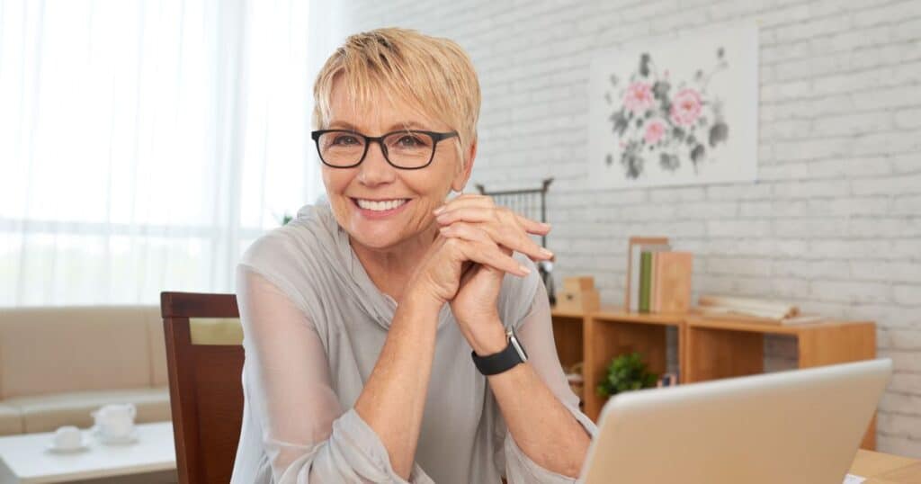 death doula business owner smiling, at desk with laptop